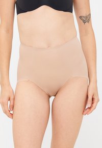 Höga trosor i en nude nyans, gjorda av ett mjukt, stretchigt tyg. Har sömlösa kanter för en diskret passform.