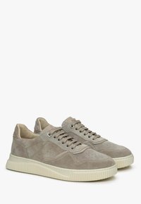 Beige suède sneakers met een gestructureerd oppervlak, geperforeerde details, tonale veters en een crèmekleurige rubberen zool met een ribbelontwerp.