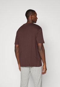 Brun kortærmet t-shirt, rund hals, lavet af blødt bomuldsstof. Simpelt design, afslappet pasform, med en glat tekstur og uden mønstre.