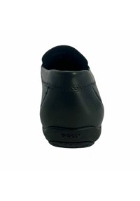 Scarpa slip-on in pelle nera con punta arrotondata, superficie liscia, dettagli di cucitura sottili e suola in gomma testurizzata con logo Geox.