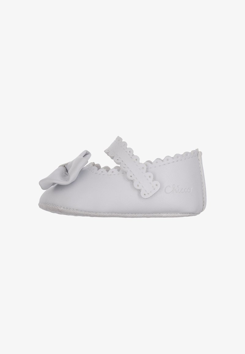 Chaussure pour bébé en cuir blanc avec bout arrondi, bords festonnés et un nœud décoratif. Bride en velcro pour un ajustement sécurisé. Semelle souple pour le confort.