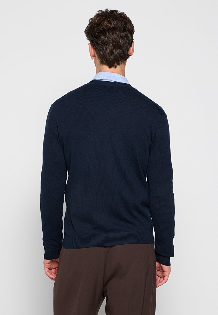 Maglione lavorato a maglia blu navy con colletto girocollo, polsini e orlo a coste, caratterizzato da una superficie testurizzata e spalle senza cuciture.