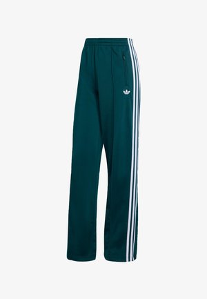 Donkergroene sportbroek met een relaxed fit, voorzien van witte zijstrepen en een klein wit logo aan de voorkant. Het materiaal lijkt glad en licht van gewicht te zijn.