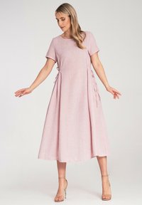Rotes Leinenkleid mit kurzen Ärmeln, lockerer Passform und seitlichen Bindebändern. Glatte Textur, knielange Länge und runder Ausschnitt.