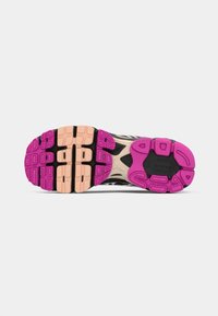 Sola de sapatilha atlética preta e rosa com um design texturizado, padrão irregular evocativo e sulcos distintos para tração e flexibilidade.