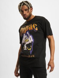 Svart bomull T-skjorte med et grafisk trykk av en figur med hevet midterste finger, omringet av fargerik tekst som sier "Tupac."