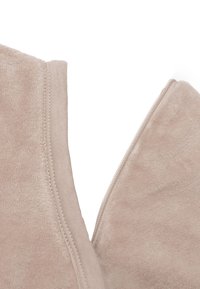 Beige fleecestof met een gladde textuur. Kenmerkt zich door een zichtbare rits en stiksels; een zachte, casual uitstraling met een subtiele glans.