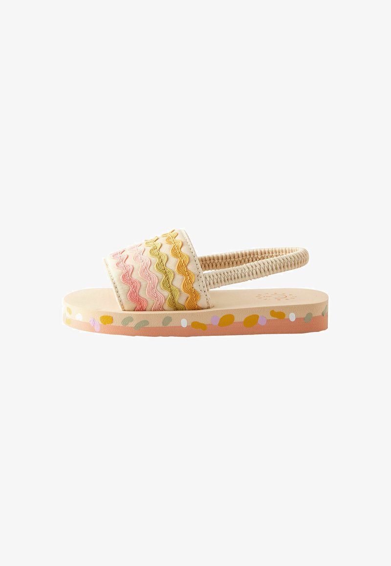 Sandale beige pour tout-petit avec bride élastique au talon, rayures ondulées colorées sur la bande avant et semelle multicolore tachetée.
