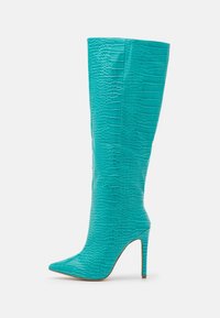 Botte turquoise montant jusqu'au genou en cuir texturé, avec un bout pointu et un talon stiletto ; motif embossé ajoutant du détail.