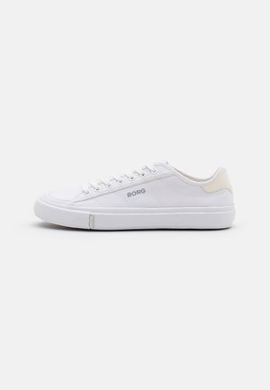 Zapatilla blanca de corte bajo con cordones, suela de goma, acento beige en el talón y logo "BORG" en el lateral y en la lengüeta de la suela, mostrada desde el lado interior.