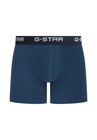 Marineblauwe boxershorts van zacht stof, met een zwarte tailleband waarop "G-STAR" in wit staat. Soepele textuur en een aansluitend ontwerp.