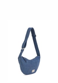 Borsa a spalla in denim blu con forma curvata, tracolla regolabile e cuciture visibili. Presenta un piccolo etichetta del brand sul davanti.