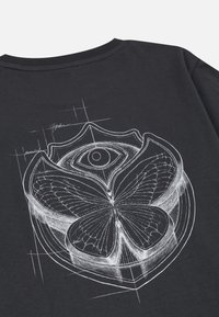 Zwarte katoen t-shirt met een witte lijntekening van een vlinder en een oog binnen een cirkelvormig, bloemachtig ontwerp op de achterkant.
