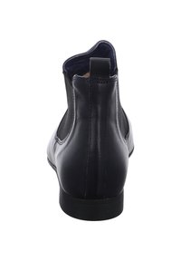 Bottines Chelsea en cuir noir avec panneaux élastiques sur les côtés et bout arrondi, présentant une finition lisse et un petit talon en caoutchouc.