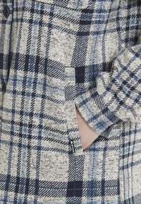 Geruite jas in blauwe en beige tinten, met een textuurstof, knoopsluiting en zijzakken met een klein logo label.