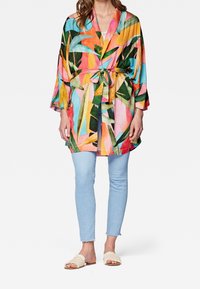 Roba in stile kimono colorata con stampa di foglie tropicali, realizzata in tessuto leggero, con cintura in vita, maniche fluenti e colori vivaci.