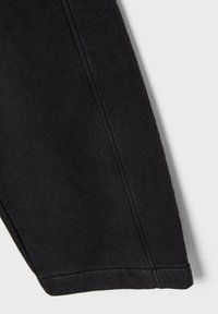 Bukser i sort bomuldsblanding med glat tekstur, lige ben og rene syninger langs sømmene samt let tilspidset ankel.