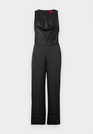Černý overal bez rukávů, s lodičkovým výstřihem a zipovým uzávěrem na zádech. Vyrobený z hladké tkaniny s dobře padnoucím střihem a širokými nohavicemi.