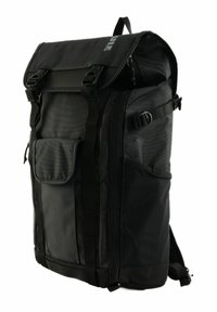 Sac à dos noir avec un design à rabat, fabriqué en tissu durable. Comprend des sangles réglables, des poches latérales et un rabat avant avec des boucles.