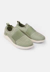 Žalios megztos slip-on tipo bateliai su storu elastingu juostu viršuje, paminkštintu padu ir tekstūruotu audinio paviršiumi.