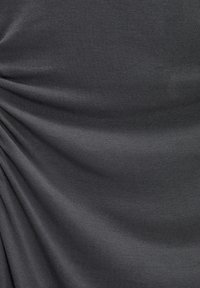 Tissu gris foncé avec une texture côtelée fine, présentant des détails froncés qui créent un effet drapé, mettant en valeur la douceur et la fluidité.