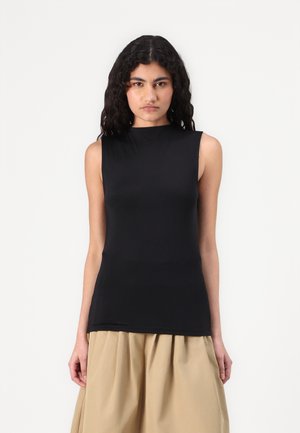 Haut sans manches noir en tissu lisse avec un col montant, design ajusté et sans coutures visibles, associé à une jupe plissée beige.