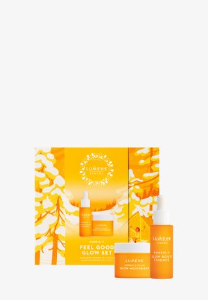 Le set Lumene Valo Nordic-C Feel Good Glow comprend deux bouteilles oranges et un pot, le tout dans une boîte jaune vibrante ornée de graphiques sur le thème de l'hiver.