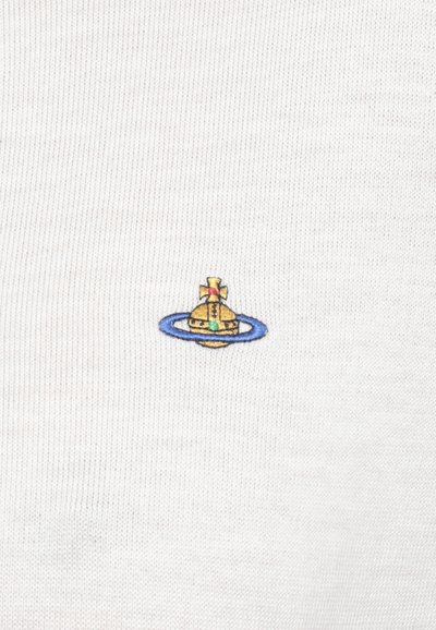 T-shirt in cotone con texture bianca, dotata di un piccolo design ricamato di un sottomarino all'interno di un anello blu con accenti rossi e verdi.