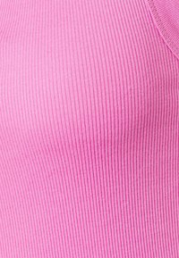 Ribbade rosa tyget med ett strukturerat mönster, som visar vertikala linjer. Materialet är stretchigt och kroppen passar utan synliga sömmar.