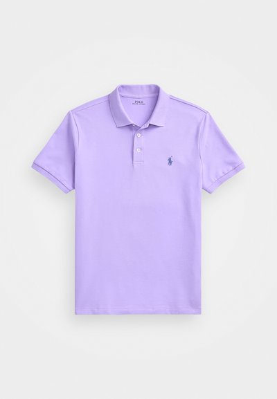 Lila polo majica od pamuka, koja sadrži klasični ovratnik, placket s tri dugmeta i malo izvezenu oznaku na lijevoj strani prsnog dijela.