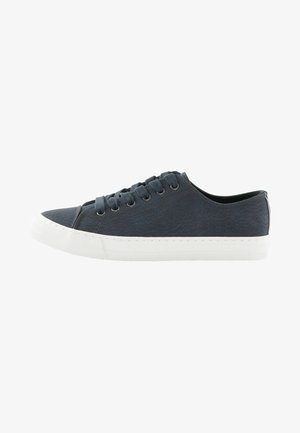 Marineblå kanvas sneakers med hvid gummisål, rund tå, seks øskener til snørebånd og tekstureret stofoverflade. Minimalistisk design.