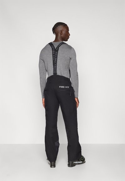 Μαύρο παντελόνι σκι με ρυθμιζόμενους ιμάντες που φέρουν το λογότυπο «FIRE + ICE». Γκρι μπλούζα μακρυμάνικη από κάτω, με απαλή υφή και άνετη εφαρμογή.