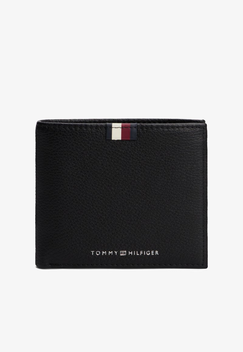 Portafoglio in pelle nera testurizzata con piccolo logo Tommy Hilfiger e etichetta in tessuto rossa, bianca e blu nella parte superiore al centro.