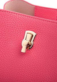 Borsa a tracolla in pelle rosa testurizzata con chiusura in tonalità oro e dettagli lisci. La superficie presenta una finitura a ciottoli per un'ulteriore texture.