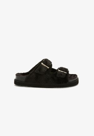 Black fuzzy slide sandal with two adjustable straps featuring silver buckles and a thick rubber sole.