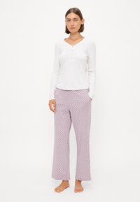 Vit långärmad henley-topp med knappar, i kombination med mönstrade pyjamasbyxor i rosa och blått med avslappnad passform och fickor.