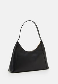 Sac à main en cuir noir avec un design courbé, une seule bandoulière et un détail de fermeture éclair doré en haut. Texturé lisse, marques minimales.