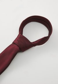 Cravate rayée bourgogne en tissu lisse, présentant une forme classique avec un centre noué et une extrémité effilée.