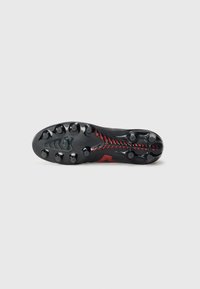 Black soccer cleat sole with red accents, featuring a textured surface, prominent studs for traction, and a streamlined ergonomic design.