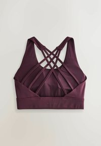 Bordeaux sportbra met een strapback ontwerp, gemaakt van rekbaar materiaal met een brede onderband en minimale branding aan de voorkant.