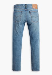 Jean en denim bleu vu de dos avec deux poches, passants de ceinture et une étiquette en cuir marron sur la ceinture.