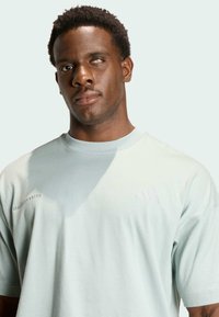 Licht muntgroen T-shirt gemaakt van zachte stof, met korte mouwen, een ronde hals en subtiele branding op de borst.