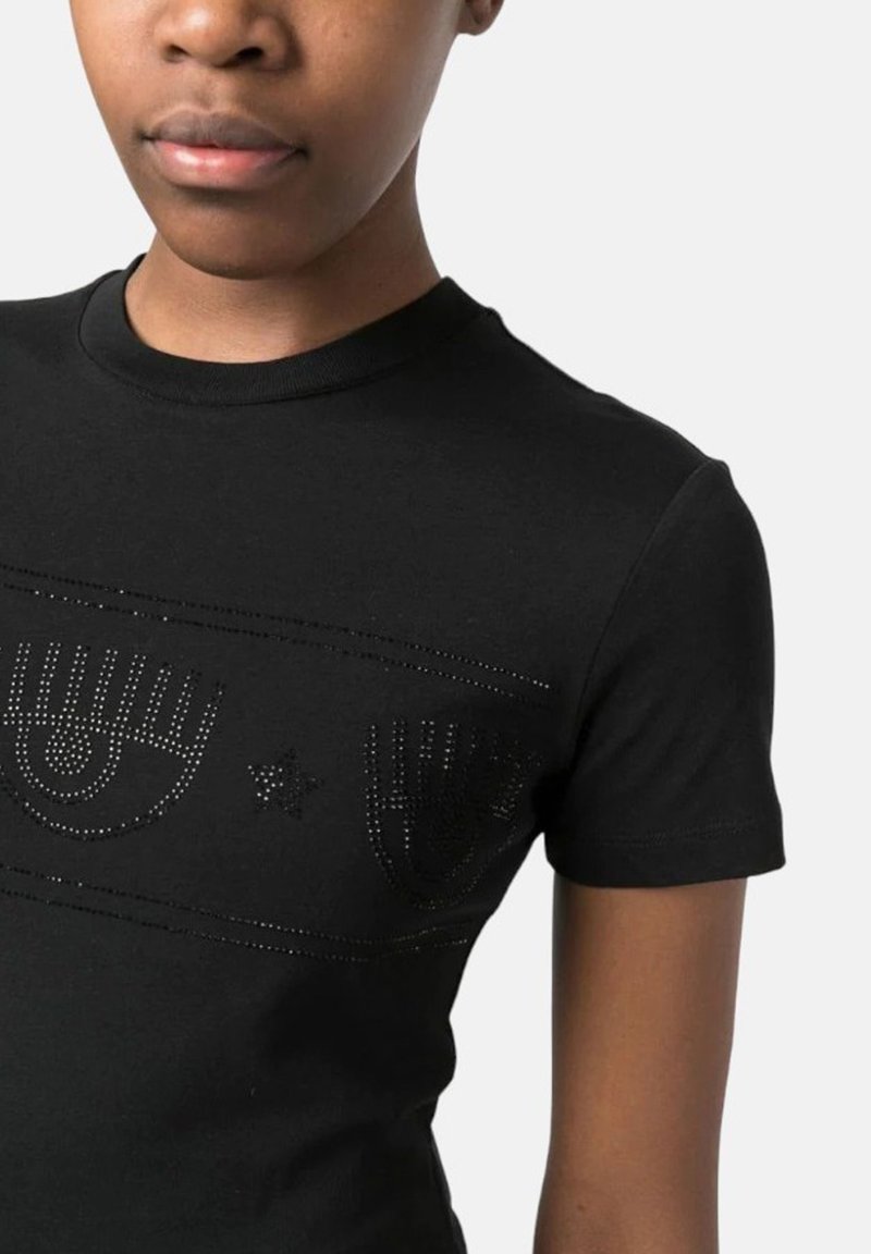 Schwarzes Baumwoll-T-Shirt mit taillierter Passform, vorne mit einem dekorativen Strassgrafik von Augen und einem Stern, kurzärmlig.