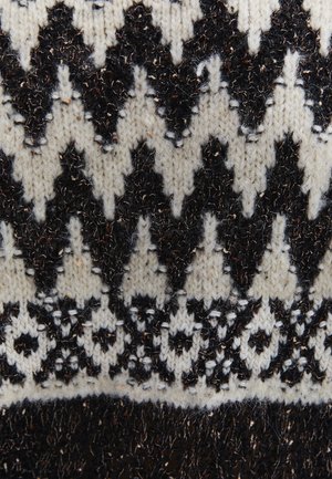 Prendas de punto con un patrón geométrico en blanco y negro con diseños en zigzag y florales, que exhiben un material de lana texturizada.