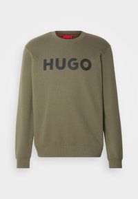 Světle olivově zelená mikina vyrobená z bavlny, s kulatým výstřihem a žebrovanými manžetami, s výrazným černým logem "HUGO" na přední straně.