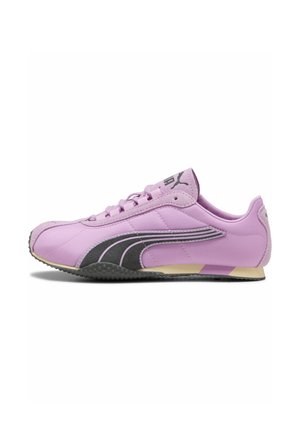 Lavprofil lilla sneaker med sort Puma-logo og snørebånd, beige og lilla sål, vist fra ydersiden på hvid baggrund.