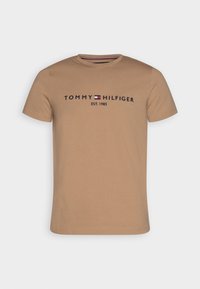 Hnědé bavlněné tričko s krátkým rukávem, s logem "TOMMY HILFIGER" v námořnické modré a červené barvě a nápisem "EST. 1985" pod tím.