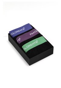 Trzy pary czarnych skarpetek z kolorowymi elastycznymi paskami: fioletowym, zielonym i niebieskim, wyeksponowane w czarnym prostokątnym pudełku.