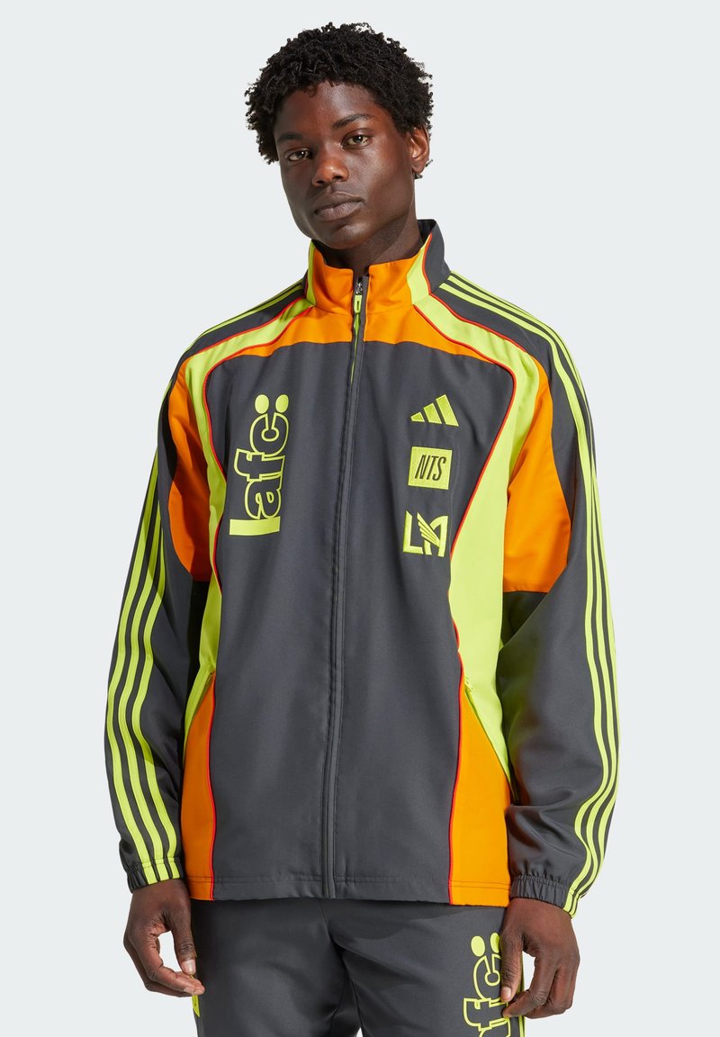 Zip-up jasje met een donkergrijze basis, levendig oranje en heldergroene accenten. Voorzien van strepen en logo's op de voorkant en mouwen.