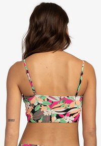 Mehrfarbiger Bikini-Oberteil mit Blumenmuster, ausgestattet mit dünnen Trägern und einem cropped Design. Hergestellt aus einem dehnbaren, glatten Material.